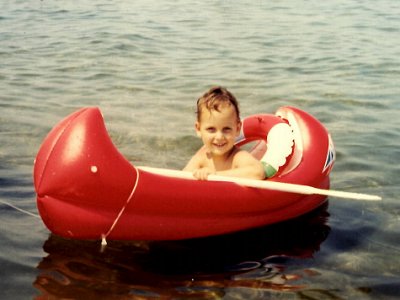 Ich als Kind in einem kleinen roten Schlauchboot